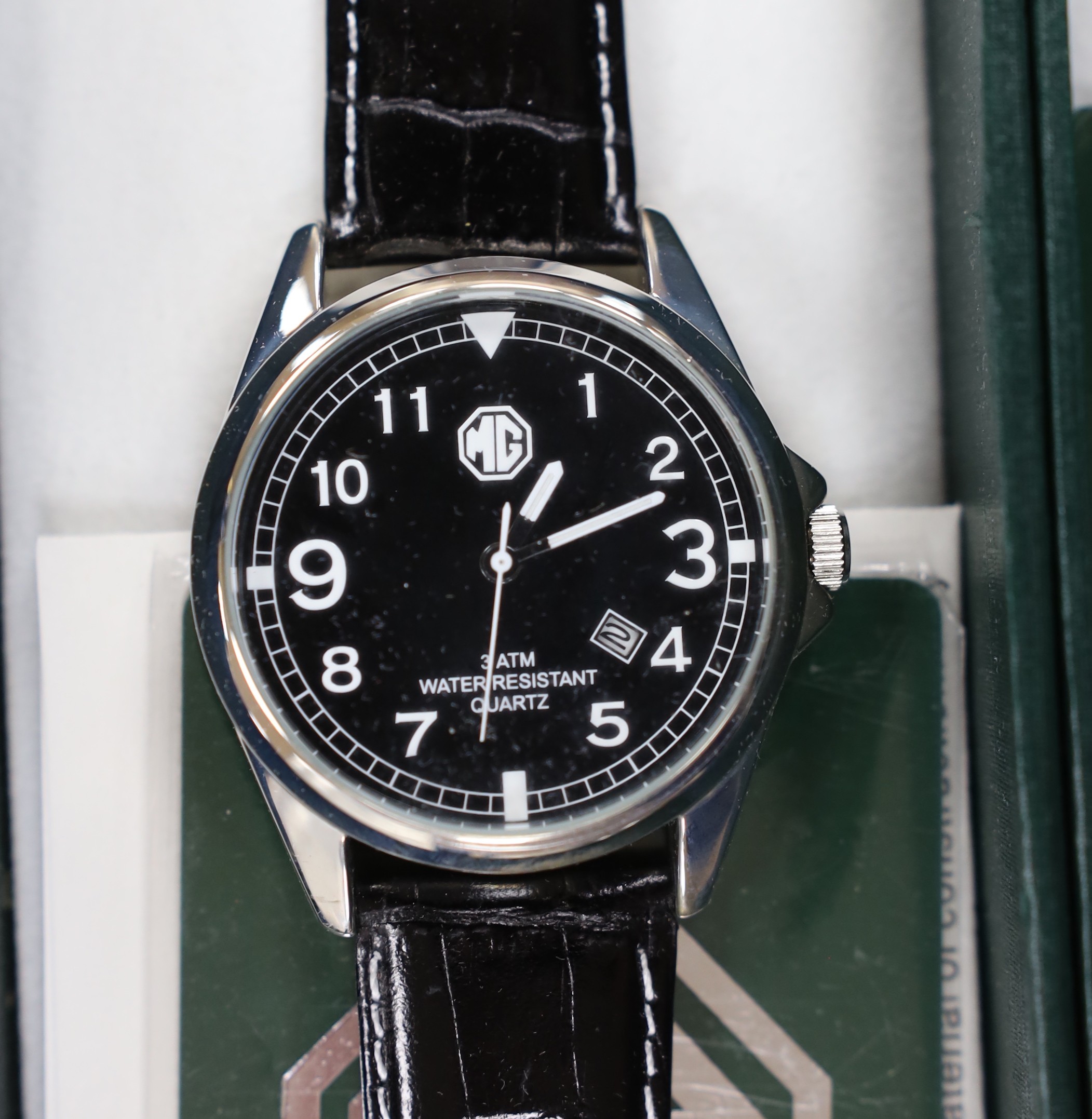 A gentleman's modern stainless steel Delorean automatic calendar wrist watch, with red face and three subsidiary dials, together with three assorted modern MG motors quartz wrist watches.